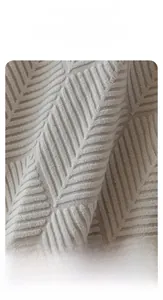 Macro detail of light beige polar fleece sofa cover with embossed geometric leaf textures