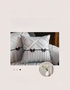 Detail of grey sofa cover featuring 3D geometric texture and elegant black bow decoration