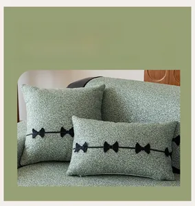 Detail showing matching square and rectangular chenille pillows with black bow accents