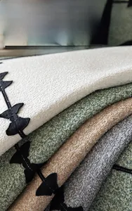 Close-up of thick chenille fabric texture with black bow embroidery in four elegant colors
