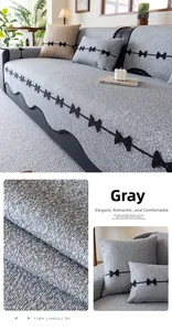 Detail of grey chenille sofa cushion with black bow embroidery and thick woven texture