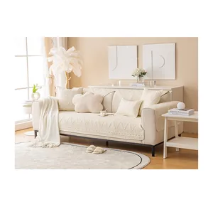 Detail der cremefarbenen Baumwoll-Sofaauflage mit 3D-Wellenstrick und Fransen