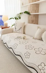 Detail of cream sofa cover with 3D floral jacquard and black wavy edges on thick velvet
