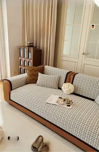 Détail de la housse de canapé en chenille avec motif à carreaux noir et blanc et passepoil