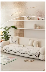 Detail of cream sofa cover with brown flower embroidery and black wavy edge stitching