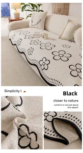 Detail of plush cream sofa cover with black wavy embroidery and non-slip backing
