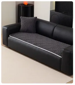 Detail of dark gray sofa cushion with textured wave pattern and white braided piping