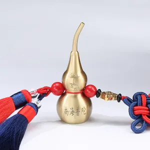Traditional Chinese brass gourd car ornament with red tassels and engraved lotus detail