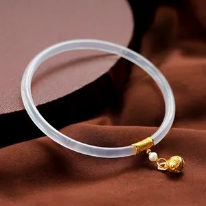 Brazalete fino de calcedonia lavanda con hilo de oro, perla y colgante de cascabel