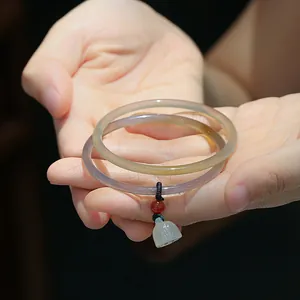 Detalle de pulseras finas de calcedonia natural con colgantes de loto de ágata