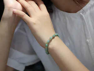 Detailed shot of natural jade bead bracelet with gold spacers on a model wrist
