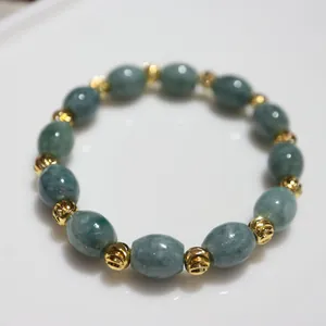 Close-up of natural green jade beads with gold threaded spacers in a beaded bracelet