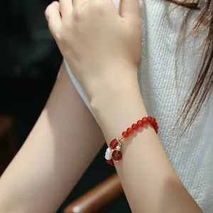 Close-up of red agate and freshwater pearl beaded bracelet worn on a female wrist