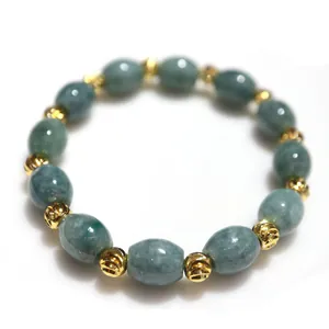 Detailed close-up of natural jadeite beads and golden metal spacers on the bracelet