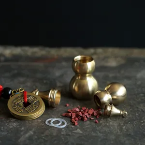 Detail of opening brass gourd pendant with cinnabar powder and ancient coin on stone