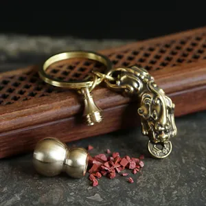 Macro detail of antique brass Pixiu charm and hollow gourd pendant for lucky keychain