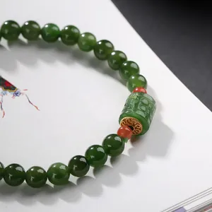 Natural green jasper beaded bracelet with carved cylinder bead and golden spacers