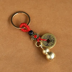 Detailed view of copper gourd and ancient coin pendant with red woven cord