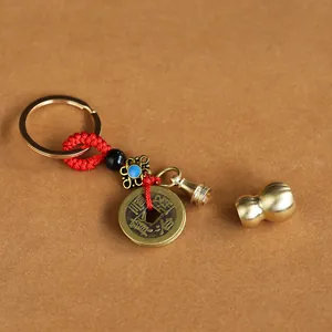 Detail of brass gourd charm with ancient Chinese coin and red woven knot on keychain