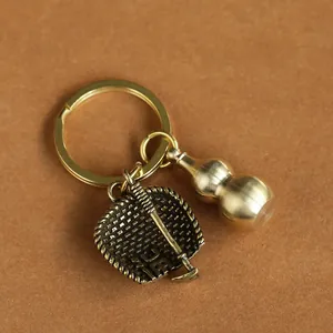 Detail of brass gourd and textured fan pendant on a vintage style metal keychain