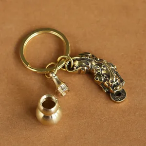 Macro shot of detailed brass Pixiu charm and small gourd bottle pendant keychain