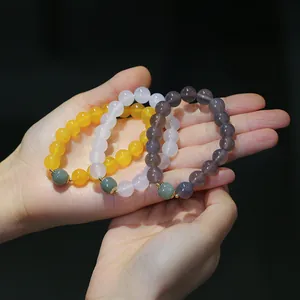 Dettaglio ravvicinato dei braccialetti in agata naturale nei colori giallo, bianco e viola