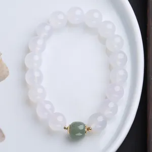 Dettaglio del bracciale di agata bianca con una perla di giada verde e distanziatori oro