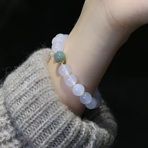 Dettaglio macro di perle di agata bianca e pietra di giada verde su bracciale di lusso