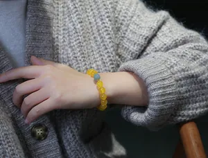 Dettaglio del bracciale con perline di agata gialla, giada verde e inserti dorati