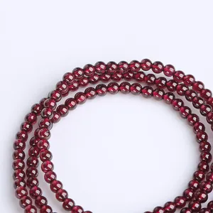 Macro shot of triple-layer natural red garnet beads with high gloss finish on white background
