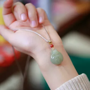 Collier pendentif Bouddha en jade vert clair naturel avec gravure fine et perle rouge