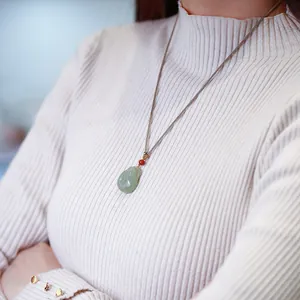 Pendentif Bouddha en jade vert clair naturel avec perle rouge sur cordon tressé