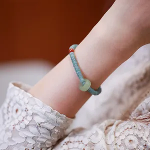 Blue jadeite abacus bead bracelet with green donut pendant on a female model wrist