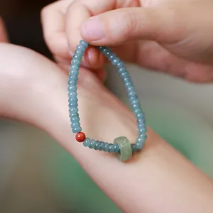 Blue jade abacus bead bracelet with a red agate accent and safe buckle charm pendant