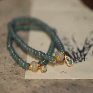 Macro shot of blue jadeite abacus bead bracelet with gold gourd pendant and jade accessories