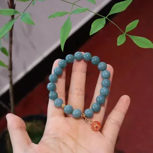 Blue jade and Yanyuan agate bracelet with golden flower charm and red bead pendant