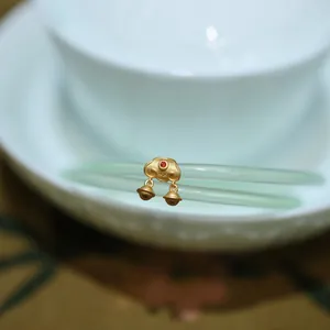 Détail de bracelet en jade calcédoine avec breloque Ruyi dorée et poinçon argent S925
