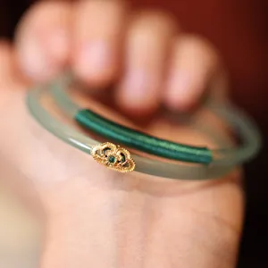 Pale green chalcedony bangle with gold filigree Ruyi motif and green gemstone inlay