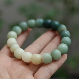 Detailopname van een gradiënt Bodhi-armband met gepolijste kralen van wit naar groen