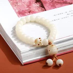 White Bodhi seed bracelet featuring a charcoal burnt cat paw bead and Maneki-neko charm