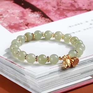 Natural Hetian jade bead bracelet for women featuring gold lotus and lotus pod pendants