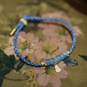 Naturblaue Jadeperlen Armband mit handgewebter blauer Kordel und goldenem Anhänger