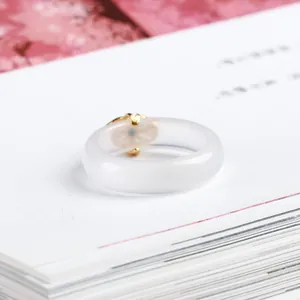 Anello in calcedonio bianco naturale con chiusura Ruyi dorata e pietra turchese blu