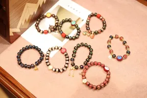 Close-up of vintage enamel beaded bracelets with traditional Chinese charms and colorful patterns