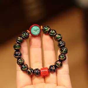Retro glazed bead bracelet with green beads, red charms and gold spiral patterns