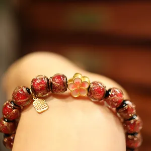 Handcrafted red glazed bead bracelet with enamel plum blossom and gold Fu pendant