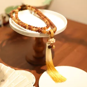 Nahaufnahme eines Lotusanhängers und langer Farbverlauf-Quaste an einer buddhistischen Kette