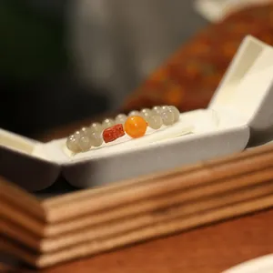 Beaded bracelet with red PiXiu and orange bead in a gray velvet jewelry box