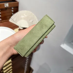 Premium dark green velvet jewelry gift box held in hand with a vintage aesthetic