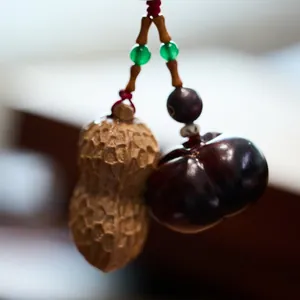 Porte-clés en bois sculpté cacahuète et kaki avec cordon rouge et perles de chance